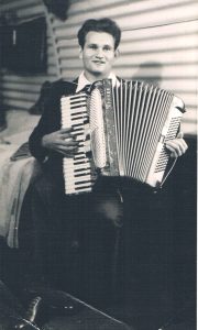 A photograph of Edward playing an accordion