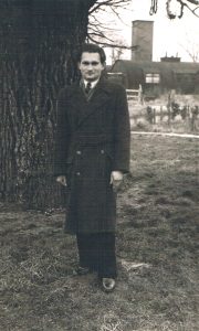 A portrait photograph of Edward Buczek standing next to a tree