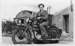 A photograph of Edward Buczek sitting on a motorbike